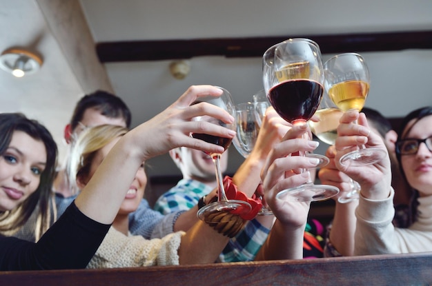 Grupo de jóvenes felices beben vino en el restaurante discoteca fiesta