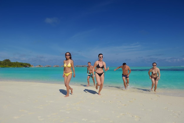 un grupo de jóvenes felices se divierten y se alegran en la playa de arena blanca en un hermoso día de verano