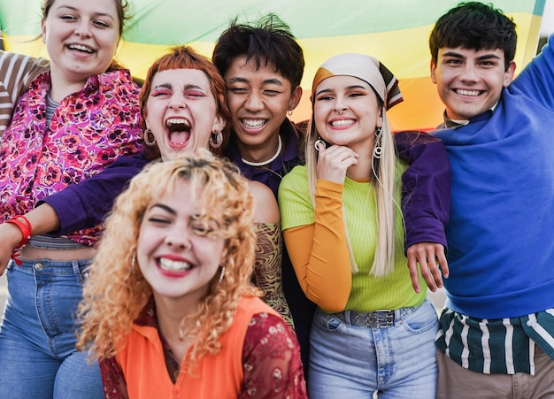 Grupo de jóvenes felices divirtiéndose juntos durante el desfile del orgullo LGBT