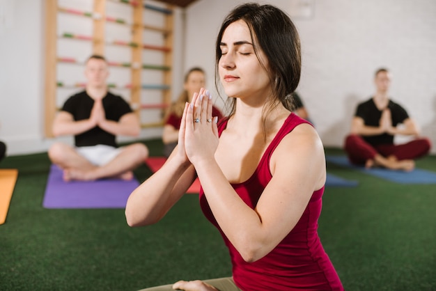 Un grupo de jóvenes haciendo ejercicios de joga en el interior del gimnasio