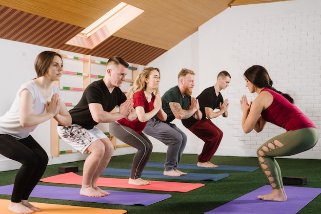 Un grupo de jóvenes haciendo ejercicios de joga en el interior del gimnasio