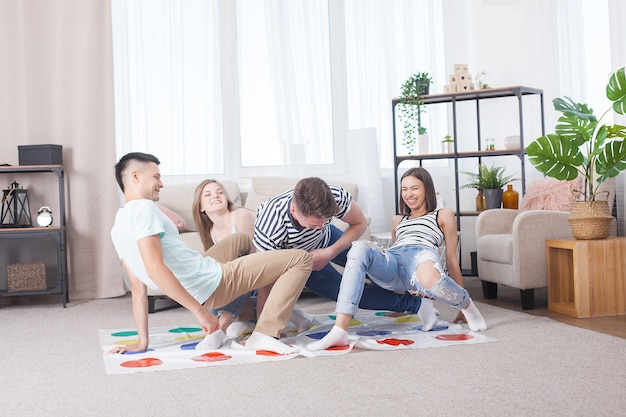 Grupo de jóvenes jugando en interiores. Amigos divirtiéndose. Juegos activos.