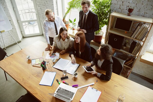 Grupo de jóvenes profesionales de negocios que tienen una reunión, oficina creativa