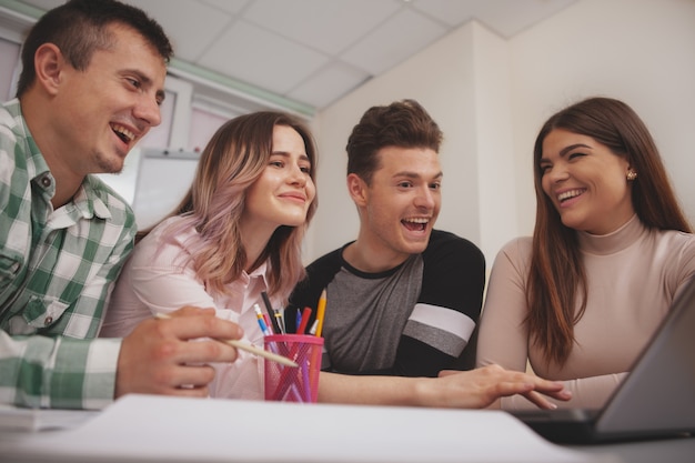 Grupo de jóvenes que estudian juntos en el aula universitaria