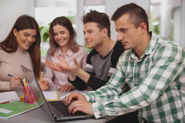 Grupo de jóvenes que estudian juntos en el aula universitaria