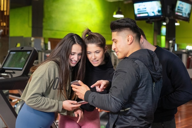 Grupo de jóvenes que usan y miran juntos el teléfono móvil.