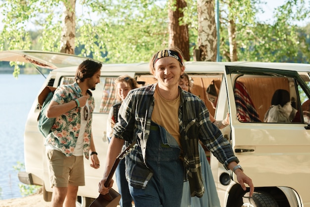 Foto grupo de jóvenes que van a acampar en el bosque en coche