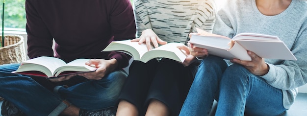 Grupo de jóvenes sentados y disfrutando leyendo libros juntos