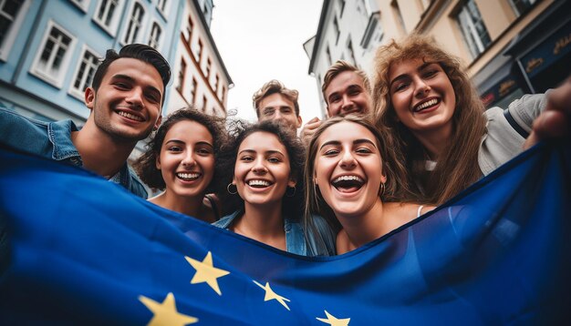 Foto un grupo de jóvenes se toman un selfie en el fondo ondea la bandera de la unión europea