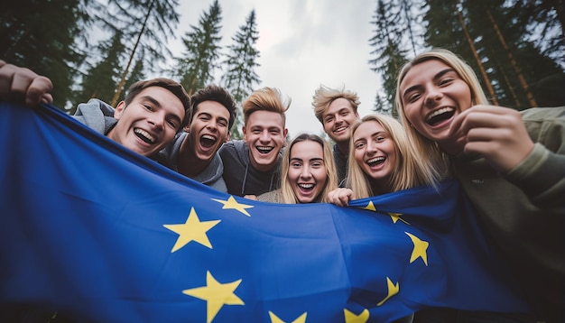 un grupo de jóvenes se toman un selfie en el fondo ondea la bandera de la unión europea