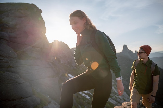 Grupo de jóvenes turistas con mochilas en las montañas recorren la ruta