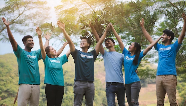 Foto grupo de jóvenes voluntarios asiáticos abrazándose levantando los brazos recogiendo poder para hacer buenas acciones concepto de voluntariado