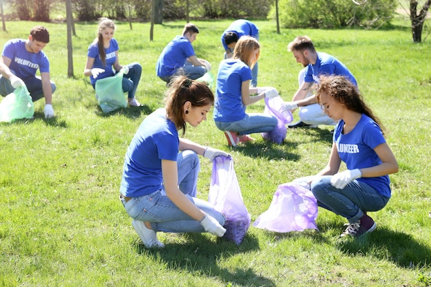 Foto grupo de jóvenes voluntarios recogiendo basura en el parque