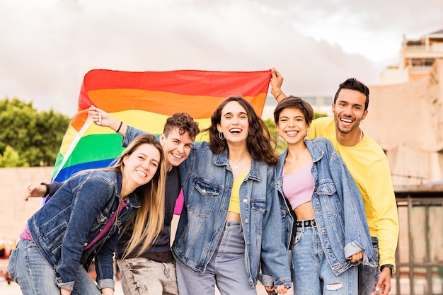 Grupo lgbtq de diversidad multiétnica con amigos de la bandera del arco iris para la expresión de género y el orgullo de la identidad