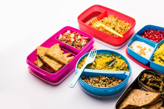 Grupo de Lunch Box o Tiffin para niños indios, que muestra variedad o opción múltiple o combinación de alimentos saludables para los niños que van a la escuela