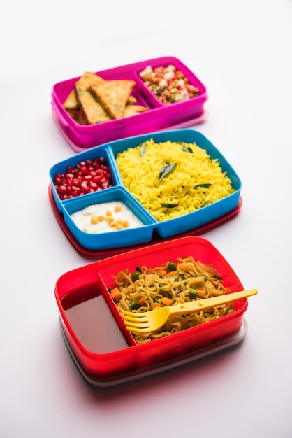 Grupo de Lunch Box o Tiffin para niños indios, que muestra variedad o opción múltiple o combinación de alimentos saludables para los niños que van a la escuela