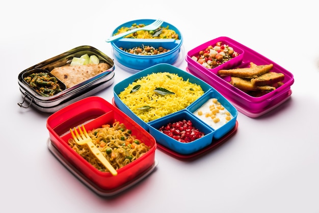 Grupo de Lunch Box o Tiffin para niños indios, que muestra variedad o opción múltiple o combinación de alimentos saludables para los niños que van a la escuela