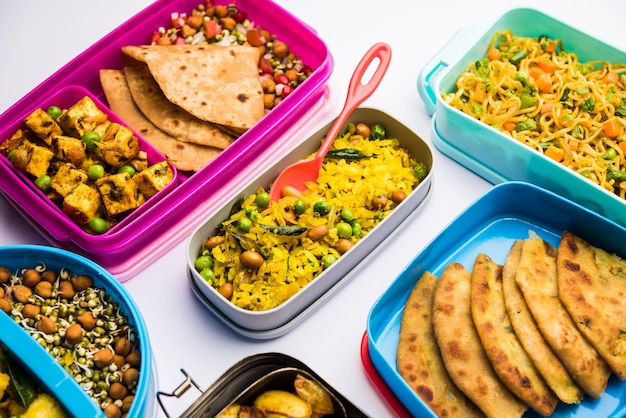 Grupo de Lunch Box o Tiffin para niños indios, que muestra variedad o opción múltiple o combinación de alimentos saludables para los niños que van a la escuela