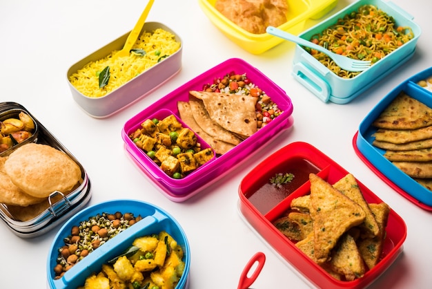 Grupo de Lunch Box o Tiffin para niños indios, que muestra variedad o opción múltiple o combinación de alimentos saludables para los niños que van a la escuela