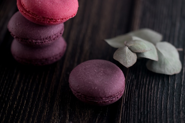 Grupo de macarons de fresas, nata, chocolate y arándanos. Foto rústica.