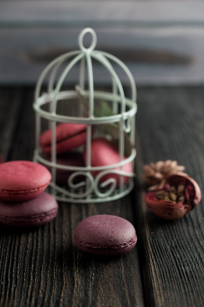 Grupo de macarons de fresas, nata, chocolate y arándanos. Foto rústica.