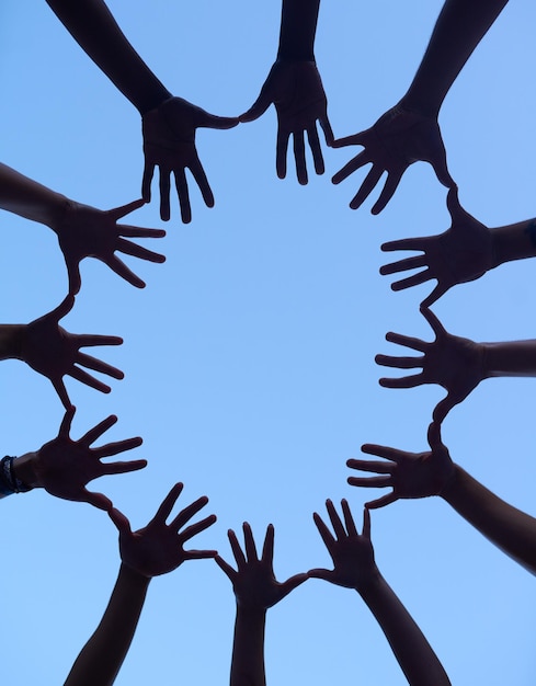 Grupo de manos y silueta para apoyo acurrucarse ángulo bajo de colaboración para la construcción de equipos y personas al aire libre Asociación solidaridad y comunidad juntos en el fondo del cielo sinergia y confianza