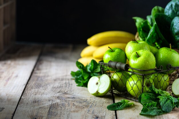 Grupo de manzanas verdes saludables, espinacas, plátanos y menta son ingredientes para un batido. Desintoxicación, dieta, concepto de comida sana, vegetariana. Espacio libre para texto. Copie el espacio.