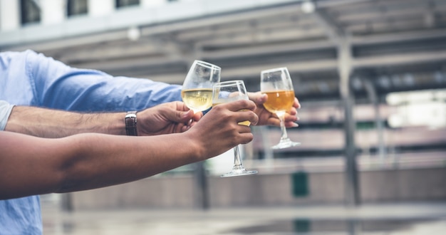 Grupo mãos tinindo copos de vinho