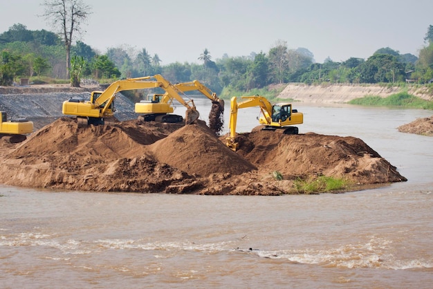 El grupo de máquinas excavadoras trabaja en el río para proteger las inundaciones