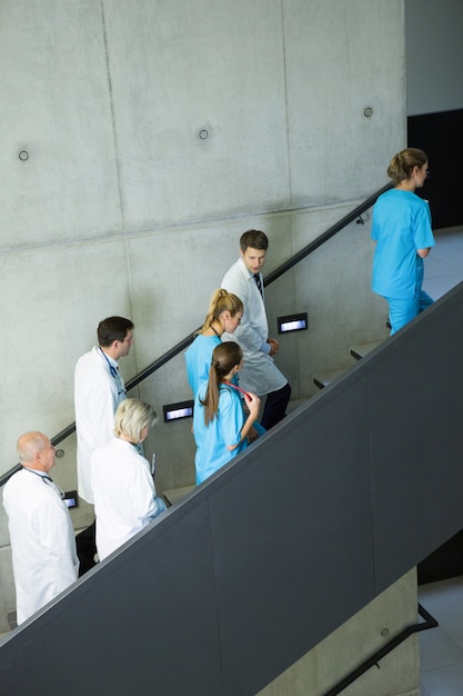 Grupo de médicos y cirujanos que interactúan entre sí en la escalera