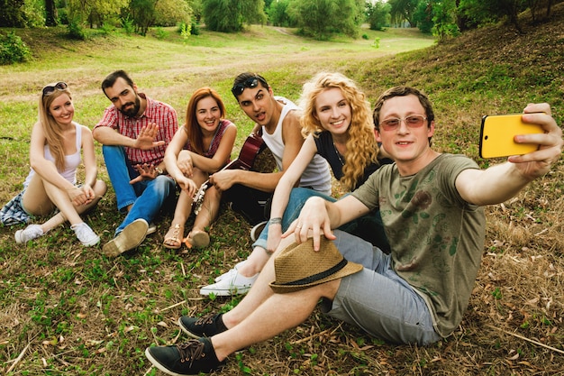 Foto grupo de mejores amigos divirtiéndose juntos, tomando una selfie