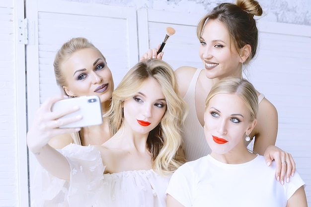 grupo de modelos maquilladas / cuatro chicas con maquillaje profesional posando en el estudio, una fiesta de bellas amigas