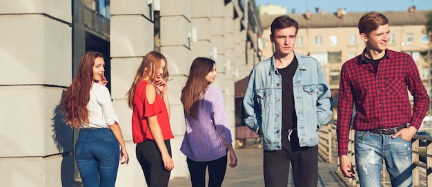 Grupo de mujer joven coqueteando con hombres en la ciudad. Amistad, ocio, estilo de vida del estudiante, primer amor, concepto de comunicación