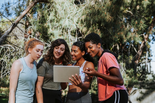 Grupo de mujeres activas mirando una tableta digital