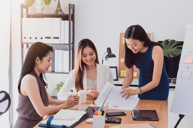 Grupo de mujeres asiáticas hermosas que se encuentran en oficina para discutir negocio.