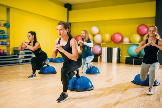 Grupo de mujeres atléticas en ropa deportiva haciendo ejercicio en entrenamiento físico. Trabajo en equipo de deporte femenino en el gimnasio.