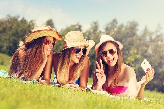 un grupo de mujeres en bikini tomando selfie al aire libre