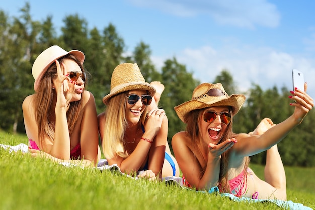 un grupo de mujeres en bikini tomando selfie al aire libre