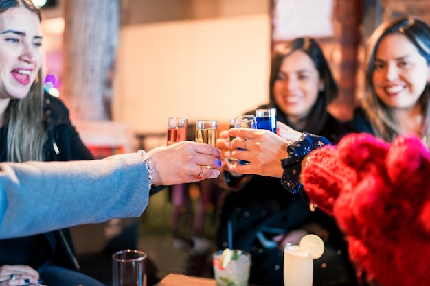 Grupo de mujeres brindando en un pub o restaurante celebrando alegremente