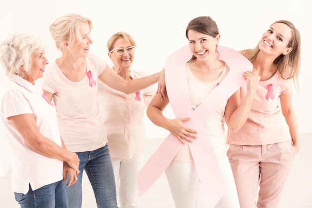 Un grupo de mujeres con una cinta rosa alrededor del cuello.