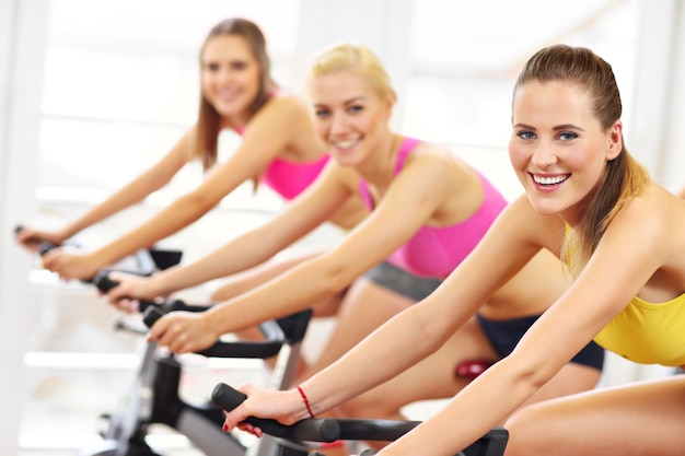 Grupo de mujeres deportivas en clase de spinning.