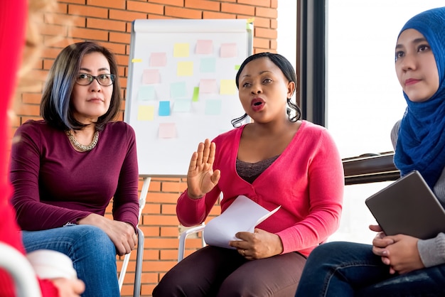 Grupo de mujeres diversas discutiendo en la reunión.