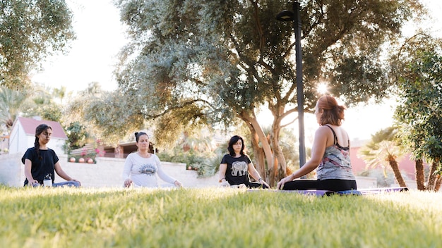 Grupo de mujeres haciendo yoga al aire libre en un parque