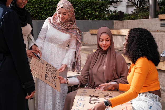 Foto grupo de mujeres con hijab sosteniendo pancartas manifestándose contra la guerra concepto de paz