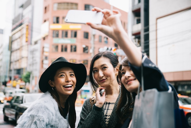 Grupo de mujeres japonesas que pasan tiempo en Tokio, haciendo compras en diferentes áreas de la ciudad