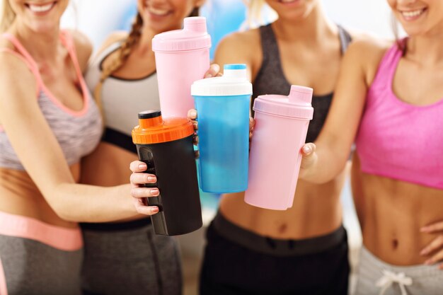 Grupo de mujeres jóvenes descansando en el gimnasio después del entrenamiento