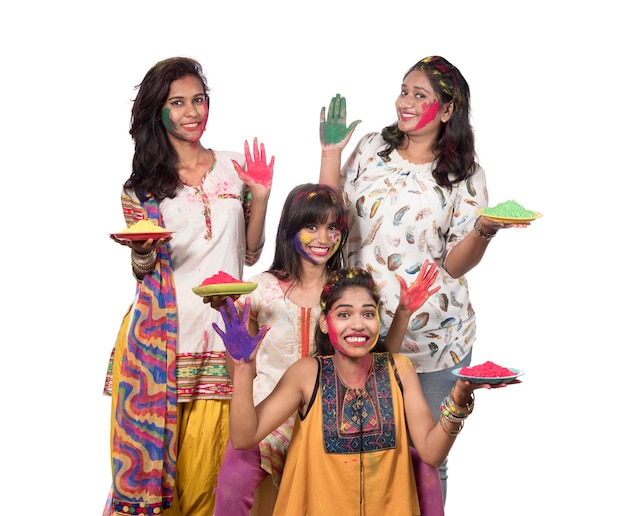 Grupo de mujeres jóvenes felices divirtiéndose con polvo de colores en el festival de colores de Holi