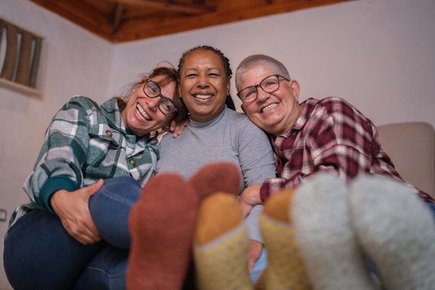 Grupo de mujeres mayores que pasan una tarde de invierno junto a la chimenea Calcetines de amistad de invierno Concept