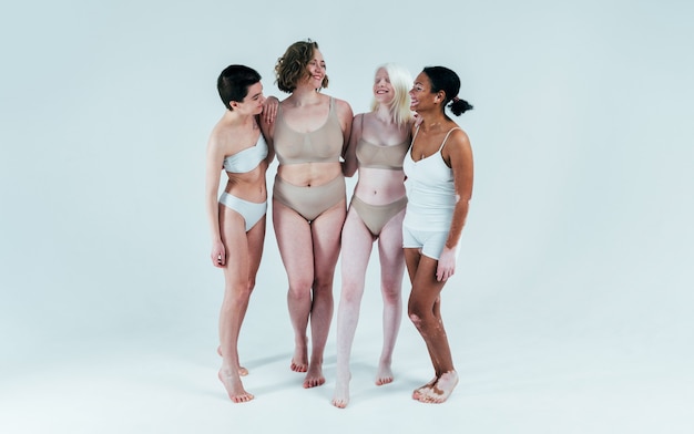 Foto grupo de mujeres multiétnicas con diferentes tipos de piel posando juntas en el estudio