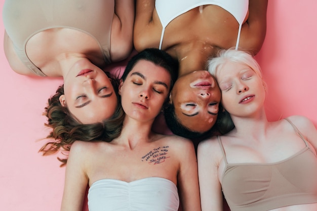 Grupo de mujeres multiétnicas con diferentes tipos de piel posando juntas en el estudio